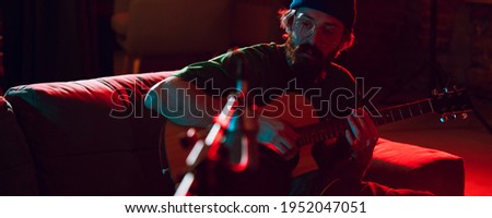 Comfortable. Close-up of musician performing in neon. Concept of advertising, hobby, music, festival, entertainment. Person improvising inspired. Flyer. Colorful modern, trendy neon lighted, artwork.