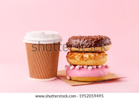 Coffee cup, stack of donuts  - take away food concept Royalty-Free Stock Photo #1952059495
