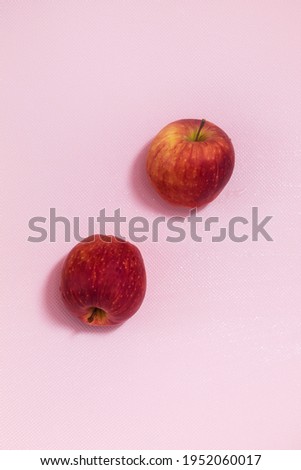 The vertical photo shows a picture of food. This apple is red in color. One apple. The apple is whole and in the skin