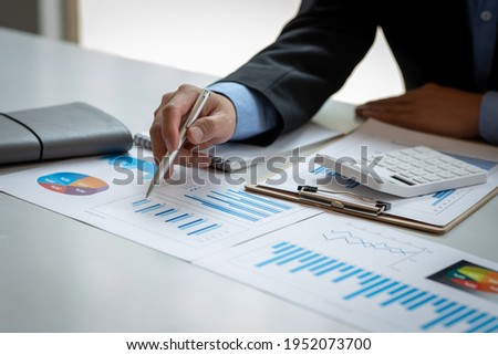 Businessman hands hold documents with financial statistic stock photo,discussion and analysis data the charts and graphs. Finance concept