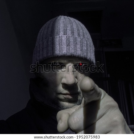 man with one red eye showing finger in camera