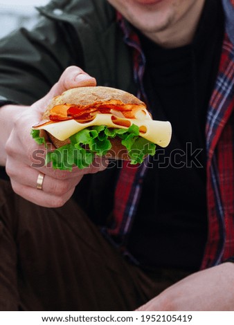 A burger in the man's hand.
