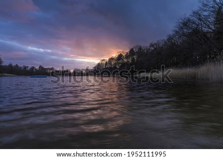 Sunset on the shore of a lake.