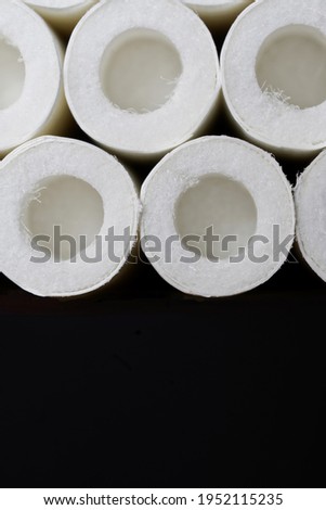 New cigarette filters with open air chambers against a dark background. Macro. Free space for an inscription