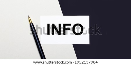 On a black and white background lies a pen and a white card with the text INFO