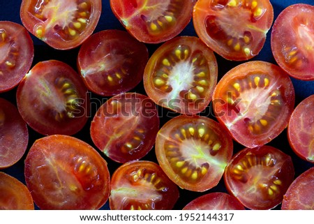 Juicy cherry tomatoes pattern close-up flatley photography. Small red tomatoes cut in half top view macro photography.