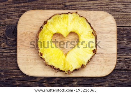 Pineapple slices with a cut in the shape of hearts on a cutting board Royalty-Free Stock Photo #195216365