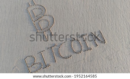 "Bitcoin" word is written on the beach sand