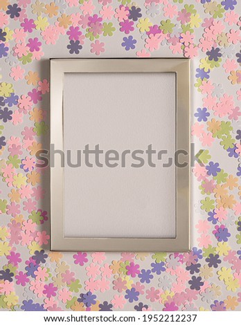 Empty picture frame with artificial flowers in pastel colors.Top view with copy space.Greeting card.