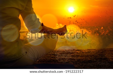 Woman Practicing Yoga by the Sea at Sunset. Beautiful Toned Photo with Golden Bokeh. Healthy Lifestyle Concept.