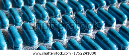 tablets in a soluble blue capsule. transparent packaging of the medicine. soft focus
