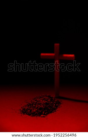 Cross from cigarettes on a red light. Symbol of death from smoking Tobacco grave death sign Cross from a cigarette against a dark background. Symbol of death from smoking . Smoking leads to death.