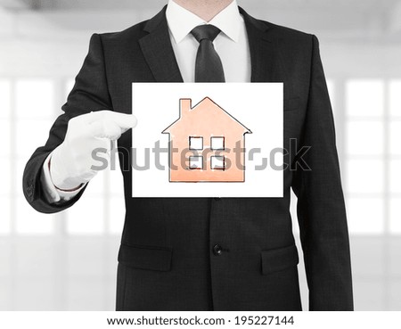 businessman holding poster with house symbol