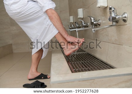 A Muslim takes ablution for prayer. Islamic religious rite Royalty-Free Stock Photo #1952277628