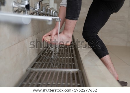 A Muslim takes ablution for prayer. Islamic religious rite Royalty-Free Stock Photo #1952277652