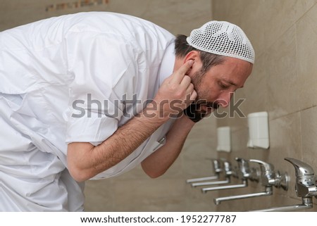 A Muslim takes ablution for prayer. Islamic religious rite Royalty-Free Stock Photo #1952277787