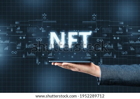 Hand holds tablet with abstract projection type of cryptographic nft Royalty-Free Stock Photo #1952289712