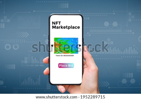 A hand holds a smartphone with an type of cryptographic NFT marketplace art with place bid Royalty-Free Stock Photo #1952289715