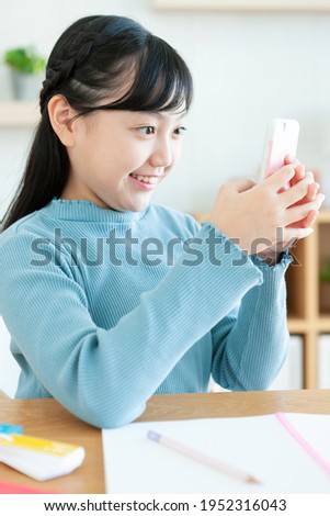 A smiling girl operating a smartphone