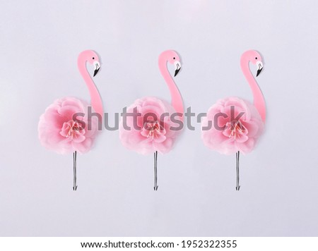 Flamingo made of cardboard and pink flowers isolated on a white background. Creative summer concept.