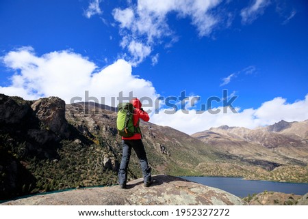 Woman photographer with camera in beautiful high altitude winter mountains