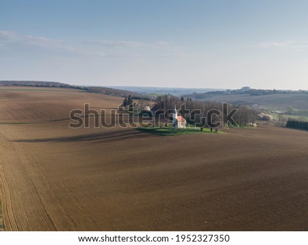 aerial photo of a small chapel with morning sunshine