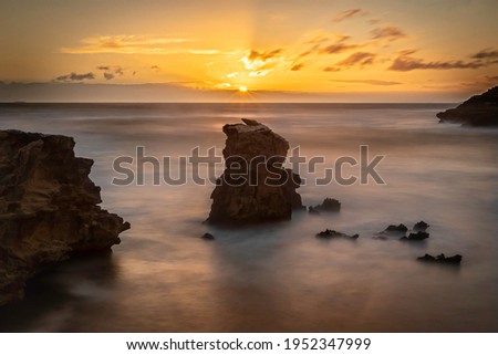 a rocky golden sunset by the ocean 