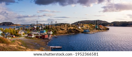 Panoramic view of a small town on the Atlantic Ocean Coast. Dramatic Colorful Sunrise Sky Art Render. Taken in Trinity, Newfoundland and Labrador, Canada. Royalty-Free Stock Photo #1952366581