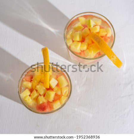 Cold sangria cocktail with white wine and fresh fruit