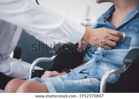 Asian doctor use stethoscope checkup  disability wheel chair patient  person ,  disability health concept