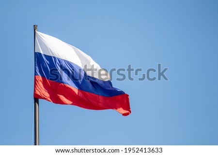 Russian flag waving against the blue sky