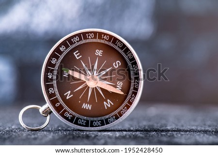 Travel planning navigation concept. Classic black magnetic detail of compass on light blue backround