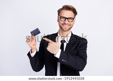 Photo of young man happy positive smile indicate finger credit card ad advice suggest isolated over grey color background