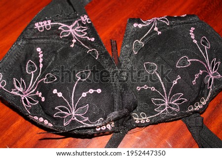 Close-up shot of the old black floral lace luxury women push up bra on the wood patterns background. 