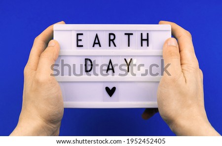 Environment concept, earth day holiday celebreation background, with text message, man hold lightbox with lettering