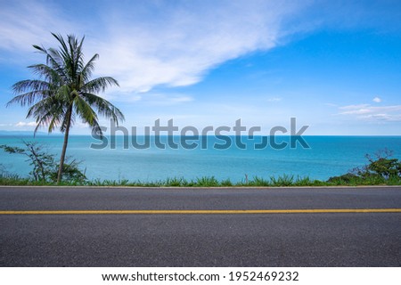 Beautiful coastal road with coconut palm tree and tropical seascape scenery background Royalty-Free Stock Photo #1952469232