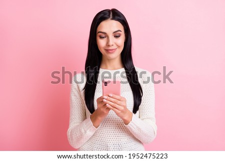 Photo portrait of woman smiling browsing internet social media with cellphone isolated on pastel pink color background