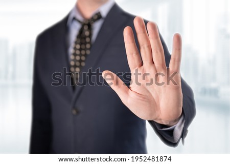 businessman gesture stop. man Showing Stop. Businessman Gesturing Stop Sign. Businessman in suit making stop gesture, holding his palm outward on blurred office background