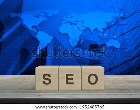 SEO letter on block cubes on wooden table over world map, modern office city tower and skyscraper, Technology search engine optimization ranking concept, Elements of this image furnished by NASA