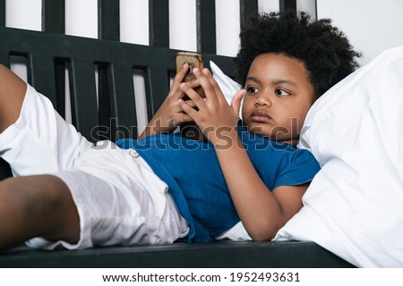 Happy black people African American child play smartphone at home 
