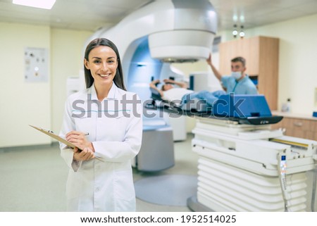 Cancer treatment in a modern medical private clinic or hospital with a linear accelerator. Professional doctors team working while the woman is undergoing radiation therapy for cancer Royalty-Free Stock Photo #1952514025