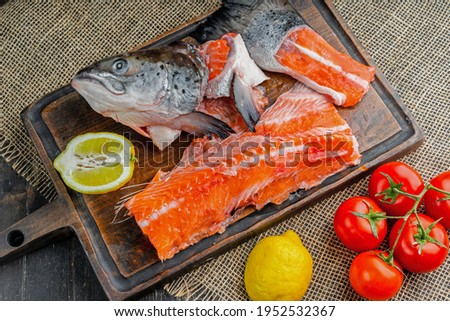 Cut salmon for soup. Head, tail, fish meat. With lemons and tomatoes.