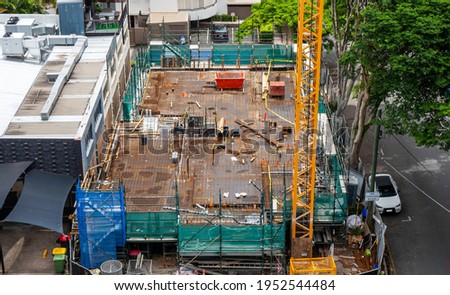 View of a real construction site from above ground. Building construction is the process of adding structures to areas of land, known as real property sites. Royalty-Free Stock Photo #1952544484