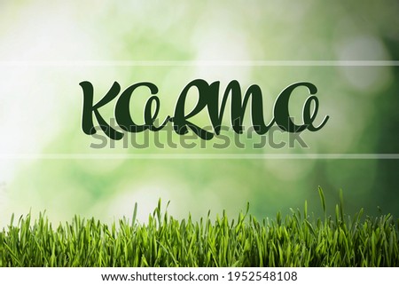 Word KARMA on blurred green background, bokeh effect 