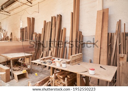 Workshop of a joinery or joinery with workbench and lots of wood Royalty-Free Stock Photo #1952550223