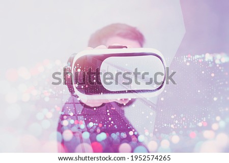Man holds in his hands glasses for virtual reality and 360-degree video. VR helmet for the smartphone on a technological bright and colored background with blur