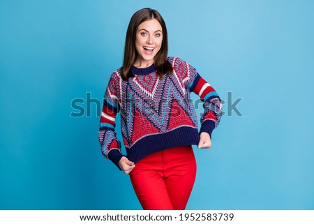 Photo portrait girl showing print on knitted sweater smiling isolated vibrant blue color background