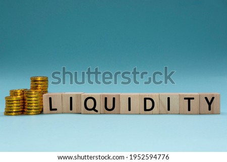 Text on wood block with a pile of coins on a blue and white background