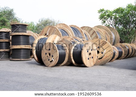 Wooden Coils Of Electrical wire Outdoor. High and low voltage cables in the storage. Large cable for electrical work. Royalty-Free Stock Photo #1952609536