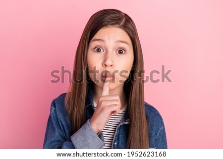 Photo portrait of small girl put finger near lips keeping secret isolated on pastel pink color background